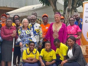 A group of persons pose for a photo. They are standing in front of the Buea School for the Deaf, where an event to launch week-long activities marking the International Day of Persons with Disabilities held.