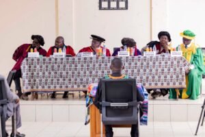 Six academic panel members at the University of Buea, dressed in academic  regalia, preside over Kesah Princely's PhD Defense.  width=